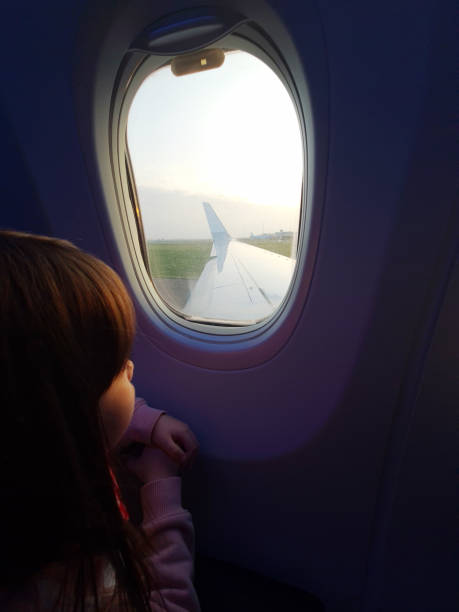 istock Girl looking at airplane window 1463856332