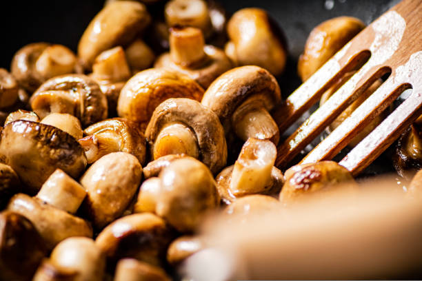 Mushrooms are fried in a frying pan. Macro background. High quality photo