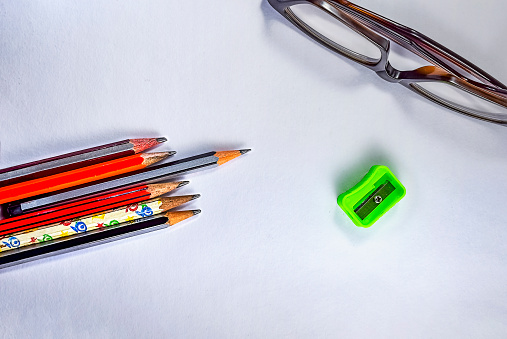 Group of multicolored school or office supplies isolated on white background. The composition is at the right of an horizontal frame leaving useful copy space for text and/or logo at the left. High resolution 42Mp studio digital capture taken with Sony A7rII and Sony FE 90mm f2.8 macro G OSS lens