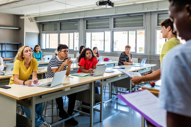 istock Young group of diverse high school students giving a presentation in classroom 1463859589