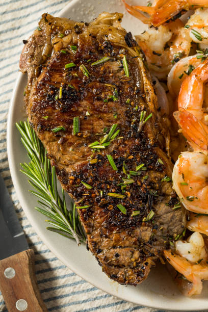 心のこもった自家製サーフと芝 - surf and turf prepared shrimp steak grilled ストックフォトと画像