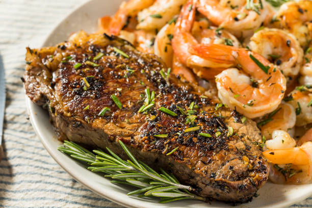 心のこもった自家製サーフと芝 - surf and turf prepared shrimp steak grilled ストックフォトと画像