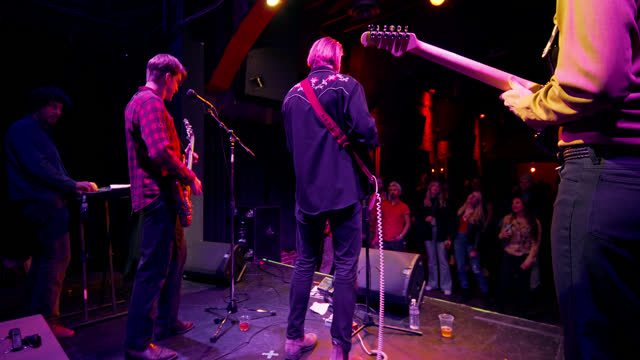 Rear View of Band Performing Onstage  with Enthusiastic Fans Watching