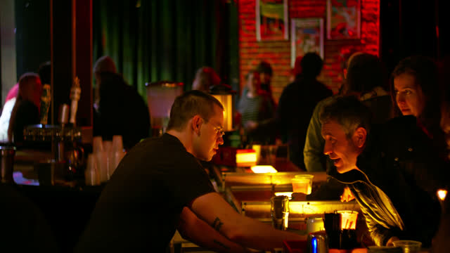Bartender Handing a Beer to a Patron During Live Show