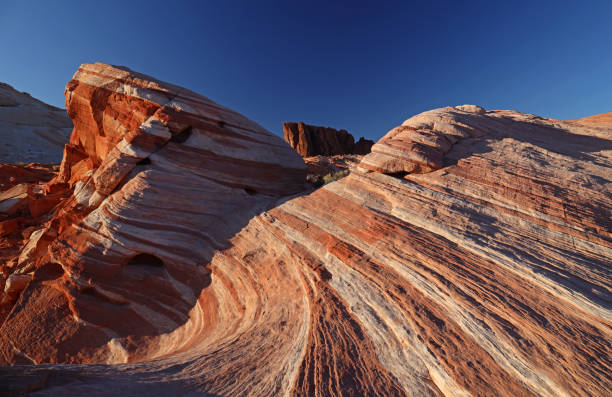 The Valley of Fire State Park, located about an hour northeast of Las Vegas, is Nevada’s oldest and largest state park, renowned for its striking red sandstone formations that glow like fire under the sun. Formed from Aztec sandstone over 150 million years ago, the landscape features dramatic cliffs, petrified trees, and ancient petroglyphs carved by Ancestral Puebloans. Popular spots include the Fire Wave, Elephant Rock, and Atlatl Rock. Visitors can hike, camp, or photograph the park’s surreal scenery. Its vivid colors and otherworldly terrain make the Valley of Fire a breathtaking natural contrast to the neon lights of Las Vegas.