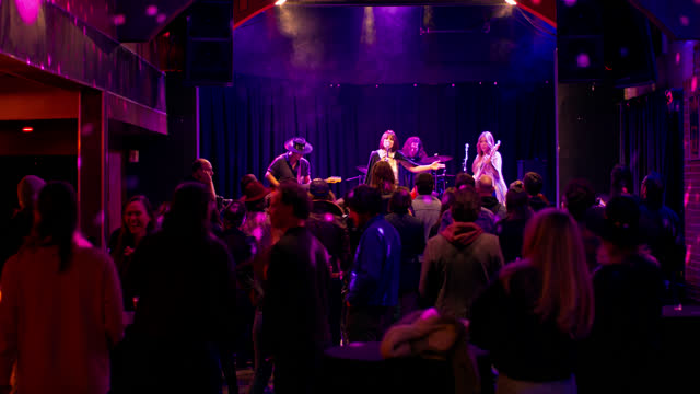 Handheld Shot of Female Fronted Band Performing at Crowded Venue
