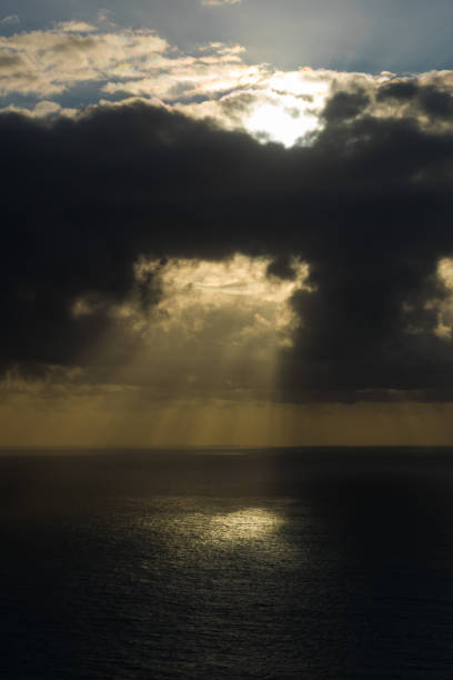 istock beautiful sunset over sea with sun rays between black clouds 1463865351