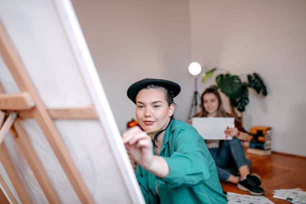 istock Young woman student creating a painting at home 1463865868