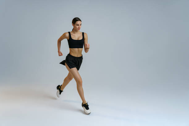 istock Sporty determined woman running during cardio workout over studio background 1463868045