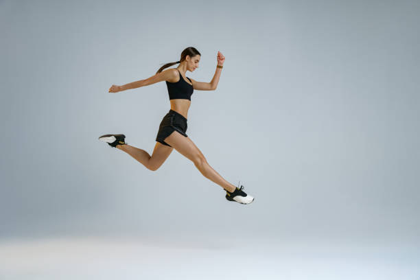 istock Sporty girl jumping doing split leap in air with joyful expression. Flexible and weightless concept 1463868131