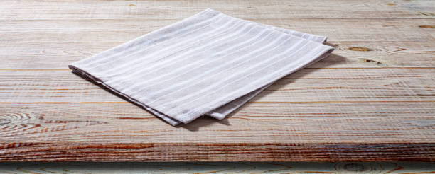 istock White napkin, table cloth on wooden deck mockup. 1463869568