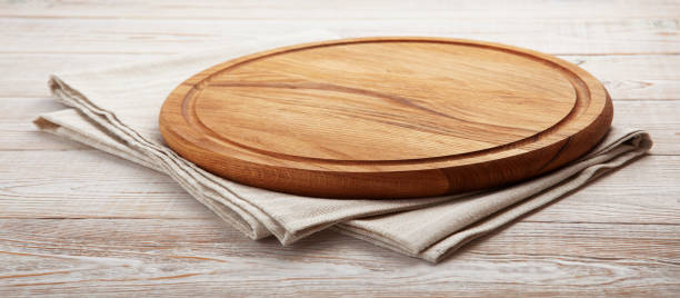 istock Empty pizza board and napkin on white wooden 1463869597