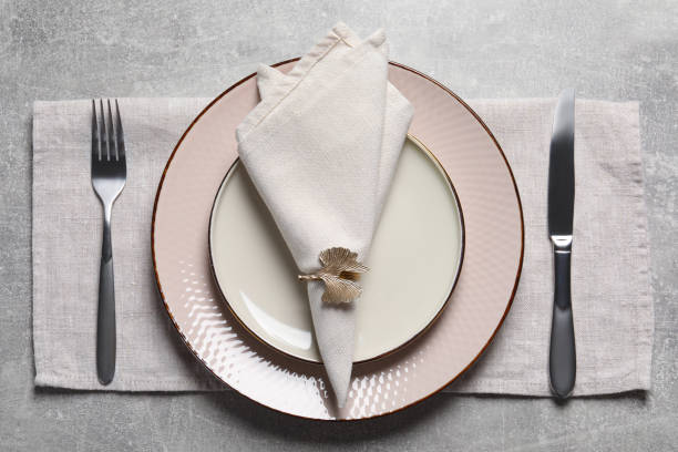 istock Plates with fabric napkin, decorative ring and cutlery on gray background, flat lay 1463869779
