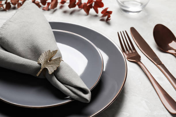istock Plates with fabric napkin, decorative ring and cutlery on light gray marble table 1463870733