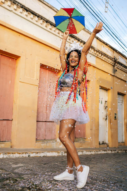 portrait of a brazilian woman during a carnival block. woman playing with confetti and frevo umbrella. - carnival parade imagens e fotografias de stock