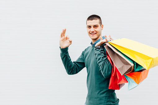 Man smiling with colorful shopping bags