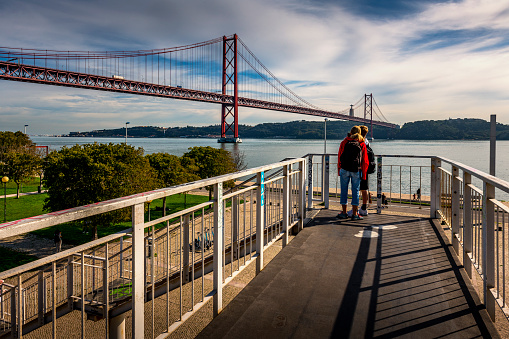 two people looking at april 25th bridge, Cristo Rei Statue and Tagus River in Lisbon