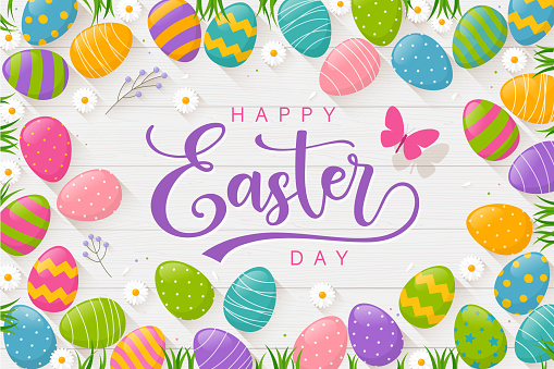 Colourful Easter eggs with coloured eggs, grass, butterfly, daisies, wood background and text Happy Easter Day