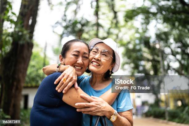 Mother And Daughter Embracing On The Public Park Stock Photo - Download Image Now - Senior Adult, Family, Friendship