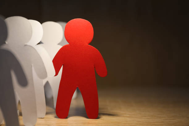 istock Red human paper figure standing out from white ones on wooden table, space for text. Responsibility concept 1463873643
