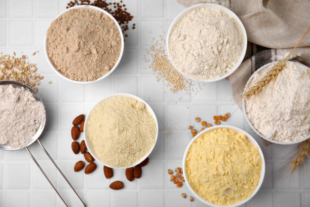 istock Bowls with different types of flour and seeds on tiled table, flat lay 1463873743