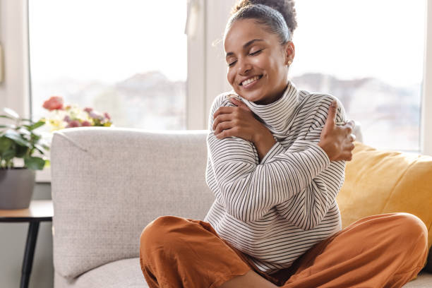 istock Smiling beautiful woman hugging self 1463874675