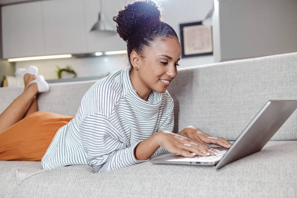 istock Young woman using a laptop at home on the sofa 1463874858