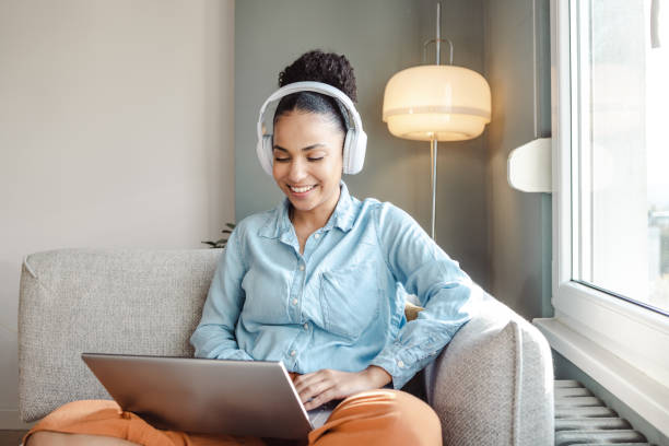 istock Young woman working on laptop at home by the window 1463875207