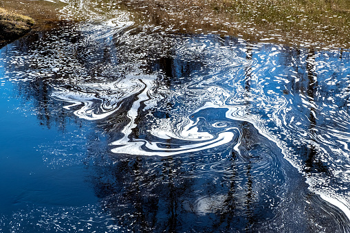 Espuma en agua contaminada, textura abstracta, extracción de agua. Concepto de contaminación natural y problemas ecológicos del medio ambiente photo