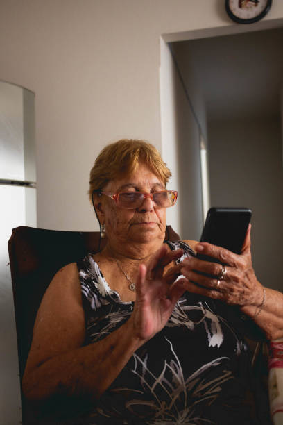 istock elderly woman uses smartphone peaceful face 1463876995