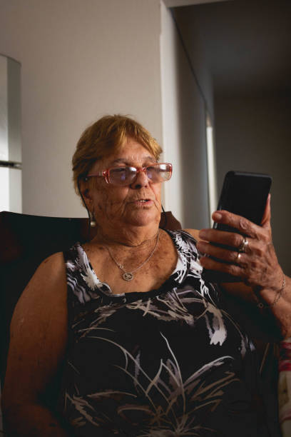 istock elderly woman uses smartphone with a surprised face 1463876998