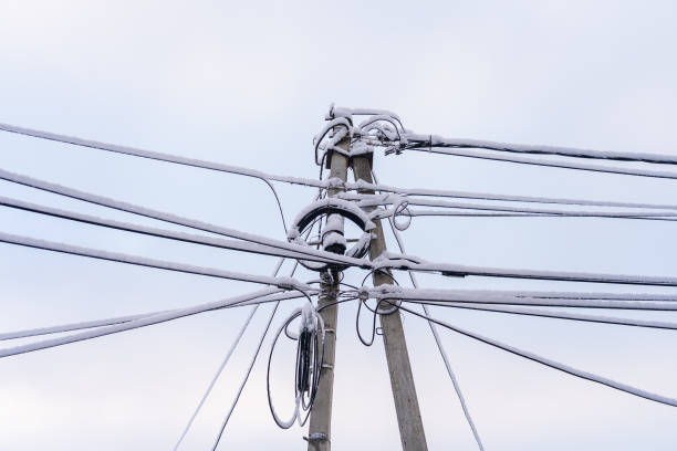 Wires on a pole in the snow. Winter background with selective focus