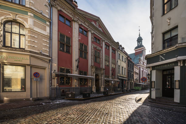 Riga, Latvia - February 5, 2023: Beautiful architecture of Old Riga. Winter view with cloudy sky and the steeple of the Reformation Church in background.