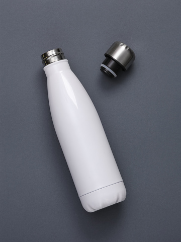 White metal thermal bottle for water on gray background. Stainless Steel Vacuum Insulated thermos Bottle