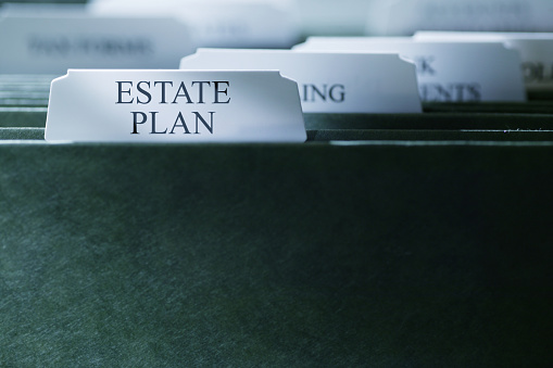 A file folder containing an estate plan photographed with a very shallow depth of field.