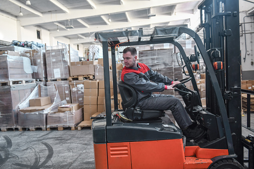 Male Warehouse Worker Showing Forklift Driving Expertise