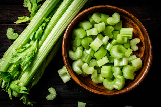 istock Sliced fresh celery. On a dark wooden background. 1463892934