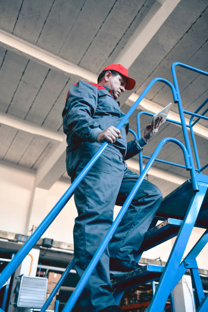istock Senior Warehouse Worker Counting Materials And Climbing On Escalator Staircase 1463892970