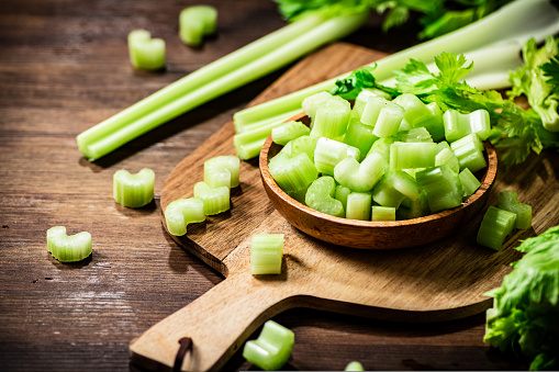 Sliced fresh celery on a cutting board. On a wooden background. High quality photo