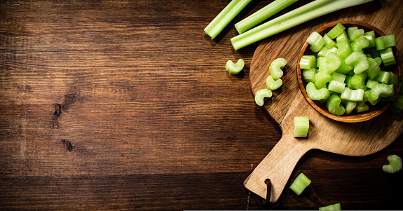 Sliced fresh celery on a cutting board. On a wooden background. High quality photo