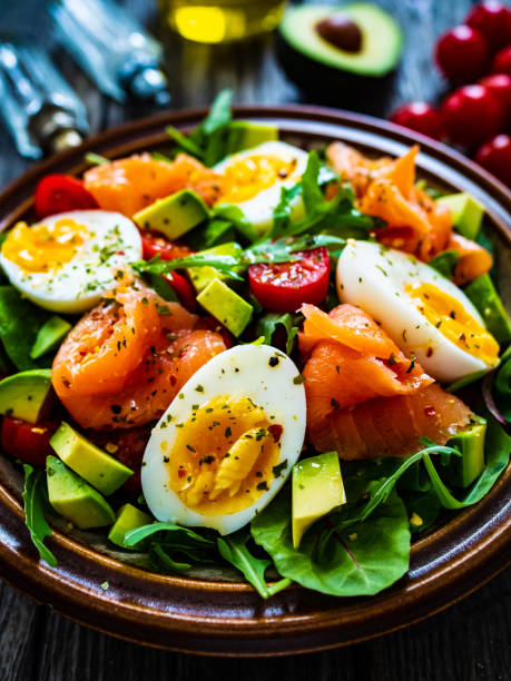 istock Smoked salmon with boiled egg, avocado and leafy vegetables on wooden table 1463893961