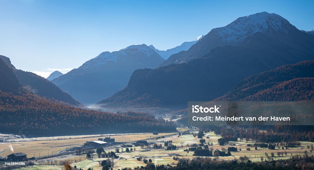 Scenic view of Engadine Valley near the town of Samedan, Switzerland Road in Engadin valley leading to the Bernina Pass, Switzerland on a sunny autumn morning. Architecture Stock Photo