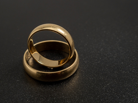Wedding rings on a black background. Gold rings. Close-up.