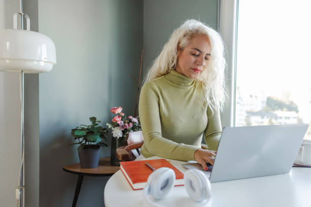 istock Focused mature woman using a laptop at home 1463902332