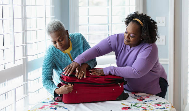 mulher afro-americana sênior, mala de embalagem da filha - luggage packing suitcase old - fotografias e filmes do acervo