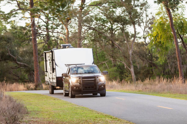 Couple driving camper trailer on rural road