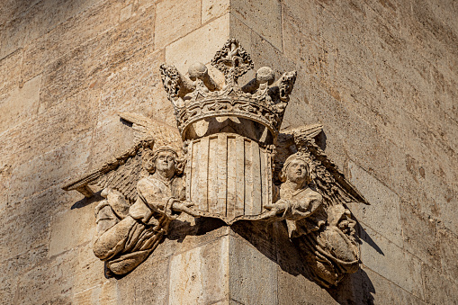 Sculpture of two angels holding a coat of arms in the wall of an historic building decleared as a World Heritage Site.