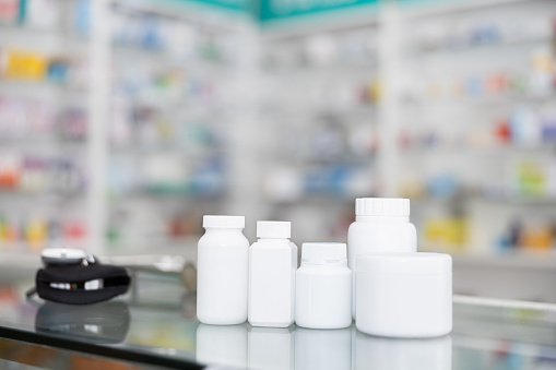 white bottle medicine on counter and shelf medicine in pharmacy  background