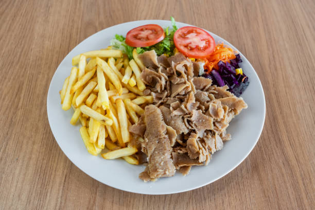 istock Kebab on a plate with fried potato salad and vegetables. 1463916329