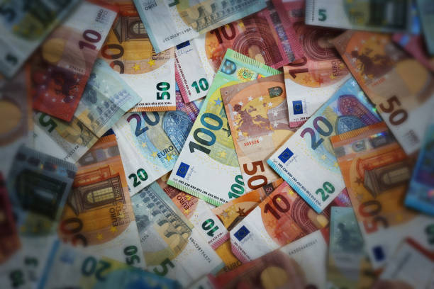 istock Many different euro banknotes, illuminated focus on the hundred euro note in the middle, dark and blurred at the edges, concept for finance, business and economy, high angle view 1463916946